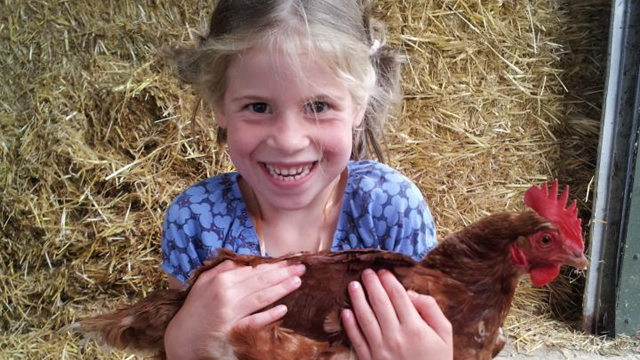 Boerderijeducatie meisje met kip